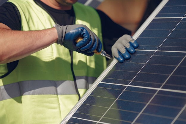 Hombre con casco blanco cerca de un panel solar