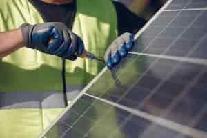 Foto gratuita hombre con casco blanco cerca de un panel solar