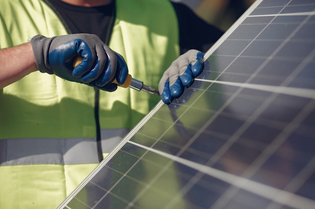 Hombre con casco blanco cerca de un panel solar