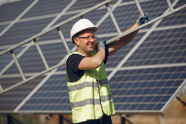 Hombre con casco blanco cerca de un panel solar