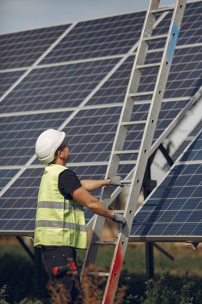 Hombre con casco blanco cerca de un panel solar