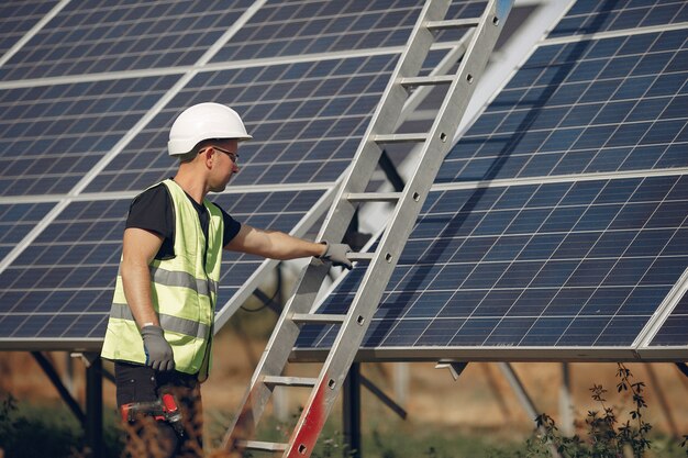 Hombre con casco blanco cerca de un panel solar