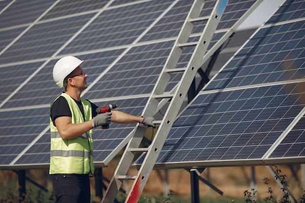 Hombre con casco blanco cerca de un panel solar