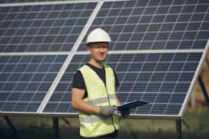 Foto gratuita hombre con casco blanco cerca de un panel solar