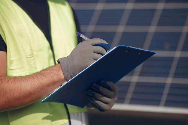 Hombre con casco blanco cerca de un panel solar