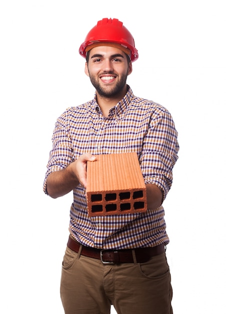 Foto gratuita hombre con un casco rojo y un ladrillo