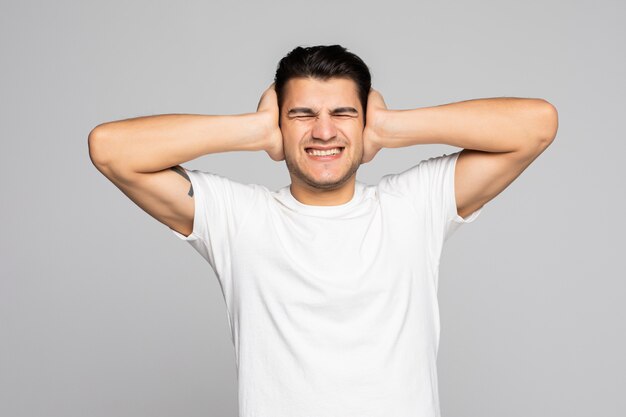 Hombre casual coning sus oídos y gritando aislado en un blanco