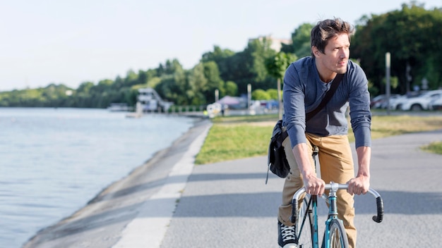 Foto gratuita hombre casual montando bicicleta al aire libre