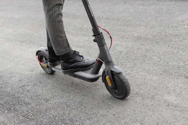 Foto gratuita hombre casual montando un scooter eléctrico