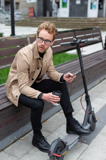 Hombre casual posando con un scooter eléctrico