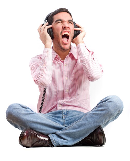 Hombre casual sentado en el suelo y escuchando música