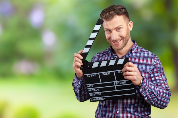 Hombre casual sosteniendo una palmada de película abierta