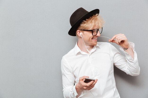 Hombre caucásico alegre con gafas escuchando música