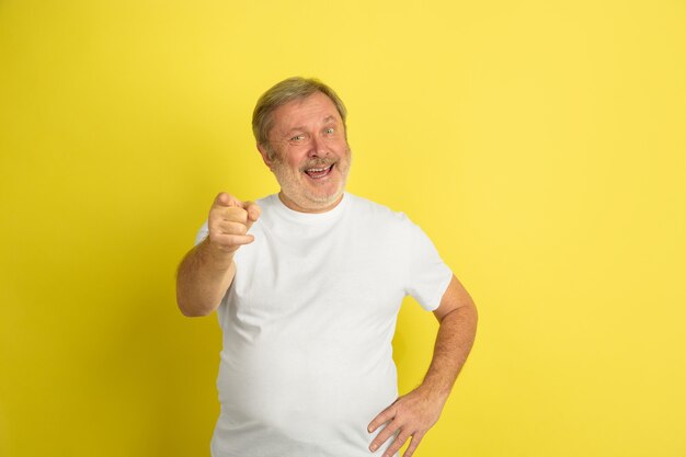 Hombre caucásico apuntando, eligiéndote en amarillo