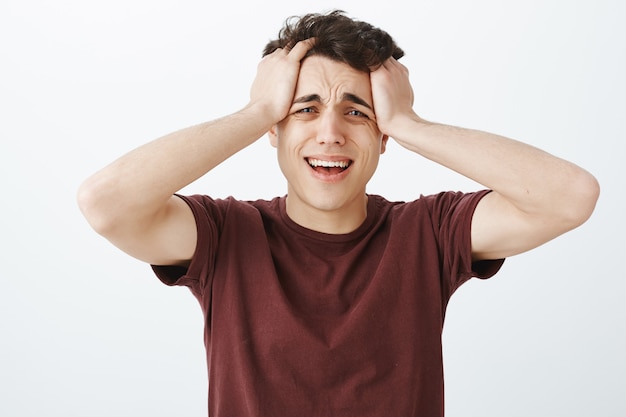 Hombre caucásico desesperado llorando en camiseta roja