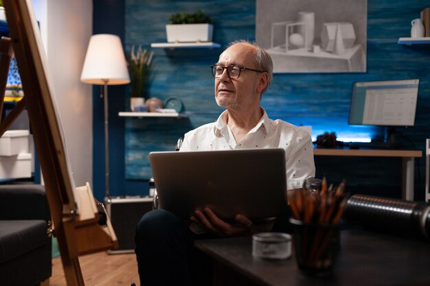 Hombre caucásico con discapacidad usando laptop para dibujar