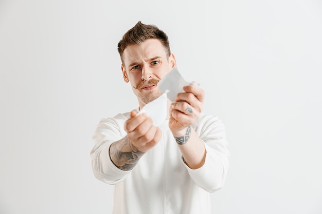 Foto gratuita hombre caucásico joven con una expresión feliz sorprendida ganó una apuesta en el estudio gris.