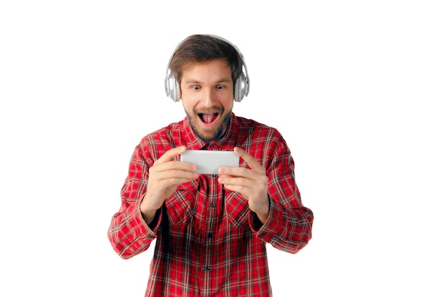 Foto gratuita hombre caucásico joven con smartphone, auriculares aislados.