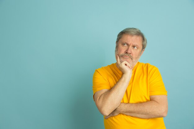 Hombre caucásico pensativo mirando al lado aislado en azul