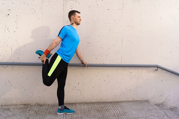 Hombre caucásico que estira entrenamiento de la ciudad