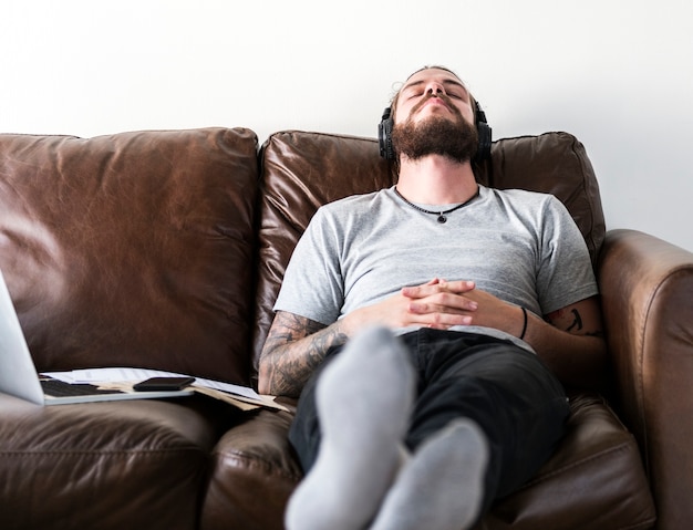 Hombre caucásico tomando un descanso del trabajo escuchando música