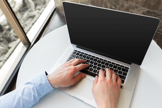 Hombre caucásico, utilizar la computadora portátil, en la mesa