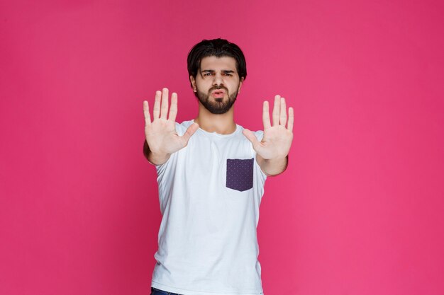 Foto gratuita el hombre cede a algo que no disfruta con las manos abiertas.