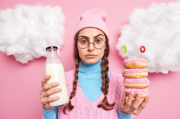 El hombre celebra el aniversario solo tiene pila de donas con velas de número botella de leche va a tener una cena festiva