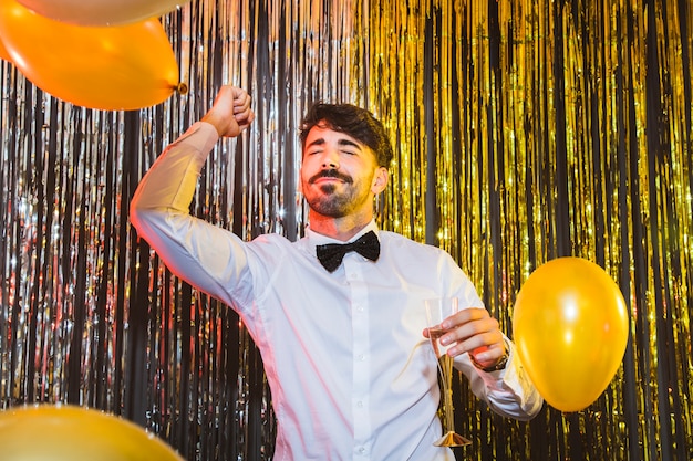 Hombre celebrando año nuevo bailando con globos