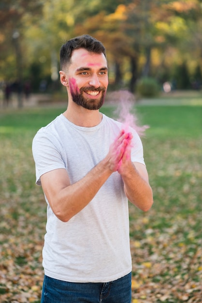 Hombre celebrando holi con colores