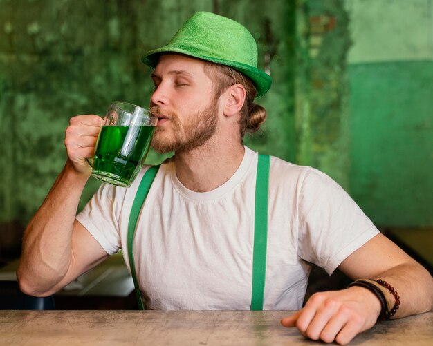 Hombre celebrando st. día de patricio con bebida