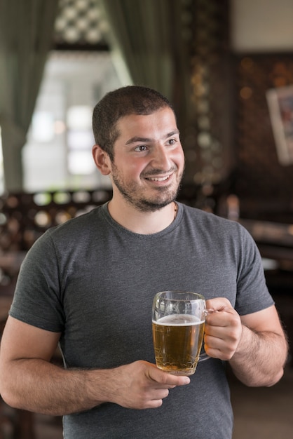 Hombre con cerveza mirando a otro lado