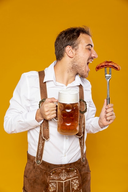 Hombre con cerveza pinta y salchichas