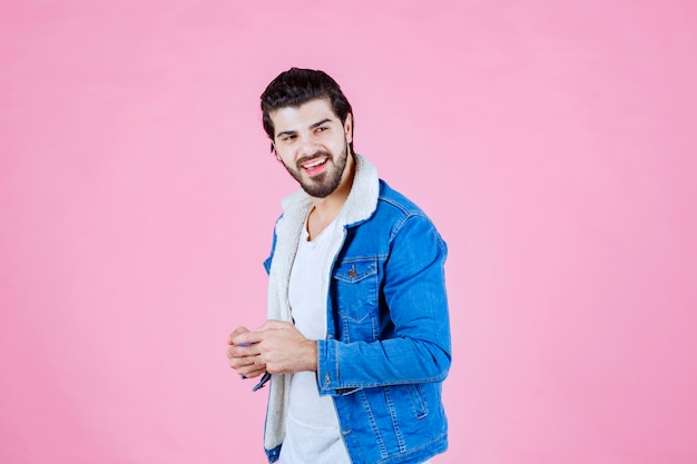 Hombre de chaqueta azul escribiendo un mensaje o comentando por teléfono.