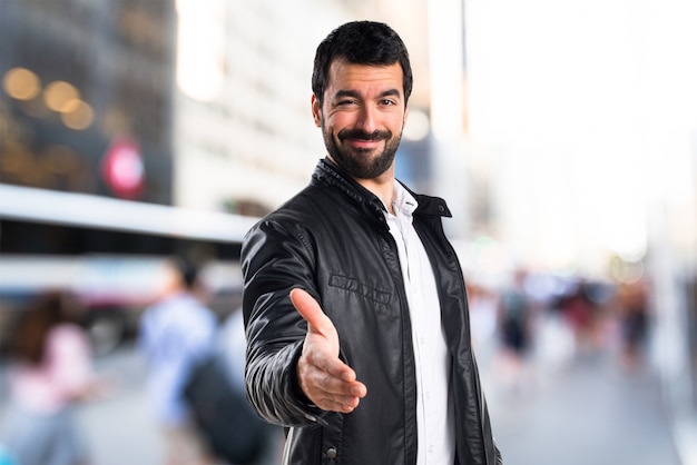 Hombre con chaqueta de cuero haciendo un trato