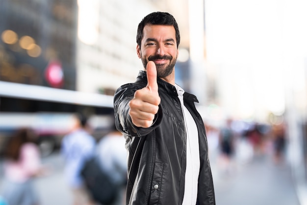 Foto gratuita hombre con la chaqueta de cuero con el pulgar para arriba