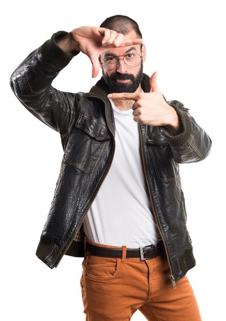 Hombre con la chaqueta de cuero que se centra con sus dedos