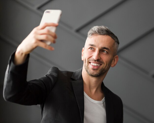 Hombre con chaqueta negra tomando una selfie