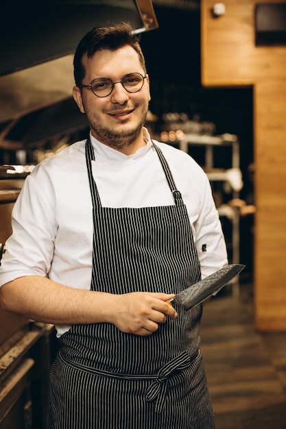 Hombre chef en la cocina con su cuchillo.