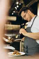 Foto gratuita hombre chef cocinando pollo asiático en la cocina de un café