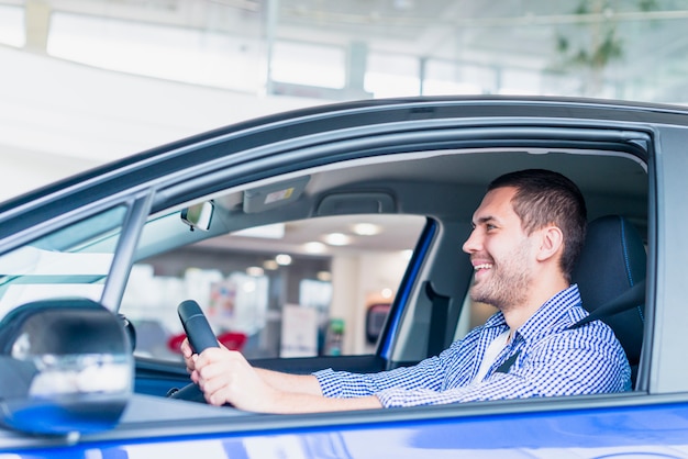 Hombre en coche en concesionario