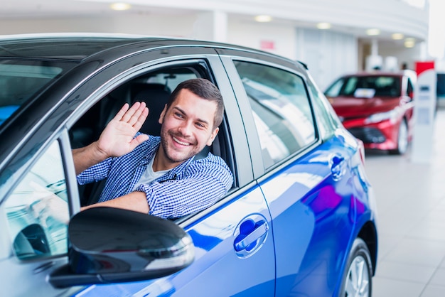 Hombre en coche en concesionario