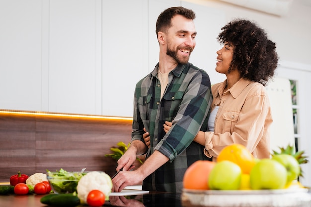 Hombre cocinando y mirando a su novia