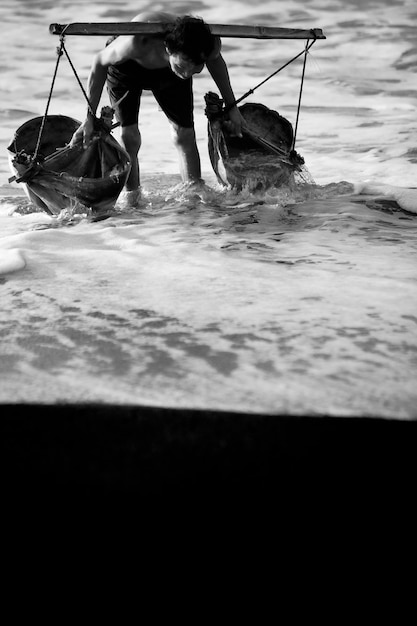 Hombre cogiendo agua del mar