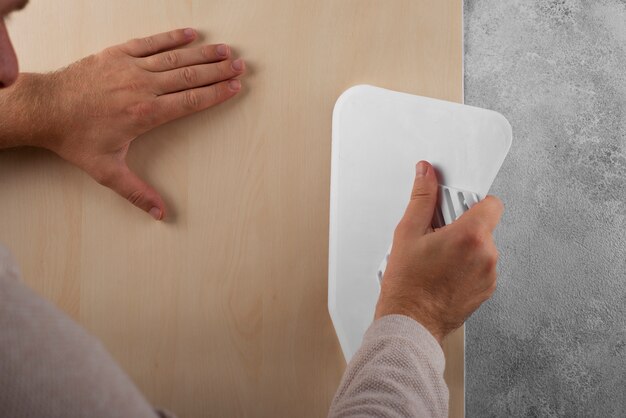 Hombre colocando vinilos decorativos con herramienta