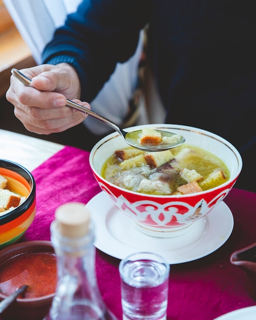 Foto gratuita hombre come sopa con galletas