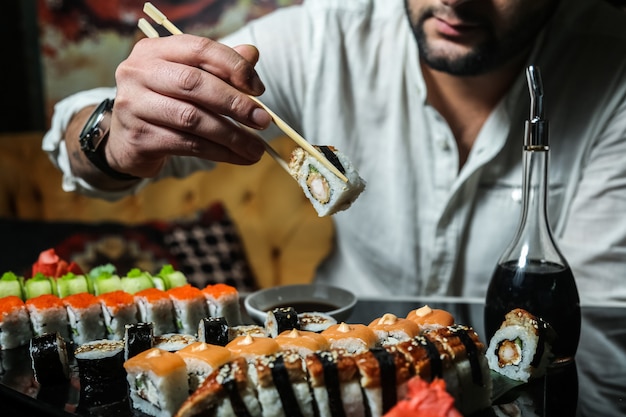 Foto gratuita el hombre va a comer sushi, jengibre, wasabi, salsa de soja, vista lateral