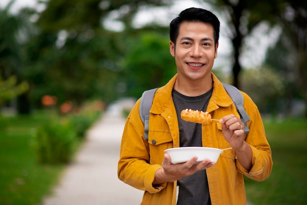 Foto gratuita hombre comiendo corn dog vista frontal