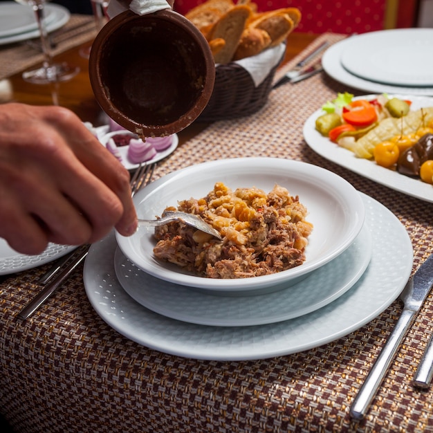 Hombre comiendo deliciosa sopa de guisantes orientales con carne en una mesa de madera. Vista de ángulo alto.