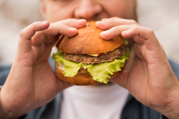 Hombre comiendo hamburguesa de primer plano